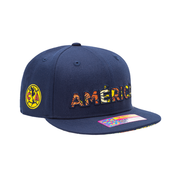 Club America Day of the Dead Snapback Hat with America script with marigold floral overlay embroidered on the front, Club America logo embroidered on the side, "Dia de Muertos" embroidered on the back, and marigold floral print on the under peak. The hat has a high crown, flat peak brim, and a snapback closure.